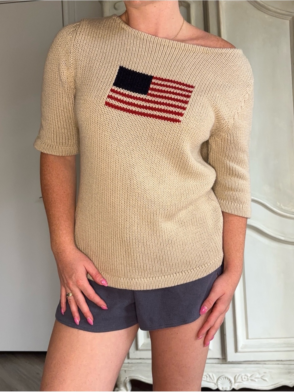 The Limited Cream Off-Shoulder Knit Sweater with Flag Motif